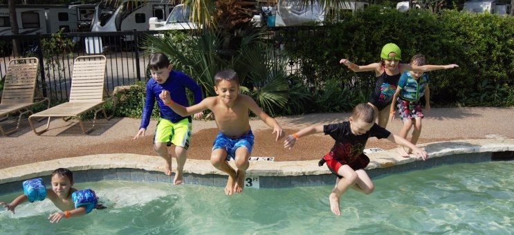 kids jumping into the pool